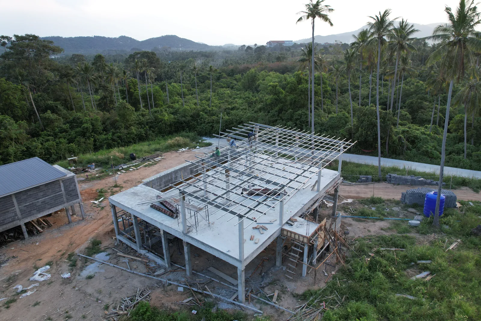 Vue drone d'une villa en construction, structure béton et charpente métallique